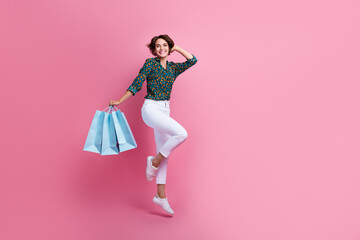 Wall Mural - Full body length photo of funny girl shopaholic addicted buying everything on sale in shopping mall isolated over pink color background