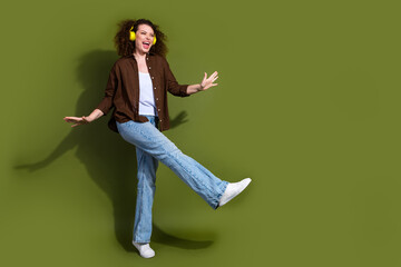 Wall Mural - Full size photo of pretty young woman dancing empty space isolated on khaki color background