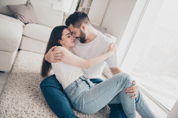 Poster - Photo of happy young couple move new place enjoy live together lying floor hugging have fun new apartment room light house flat indoor