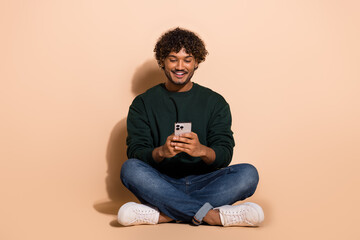 Canvas Print - Full size photo of nice young man use smart phone wear sweater isolated on beige color background