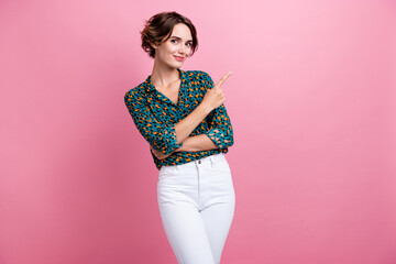 Poster - Portrait of positive woman with bob hairstyle wear print blouse indicating at discount empty space isolated on pink color background