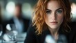 © svastix - A poised woman with red hair and a stylish black outfit sits at a sophisticated restaurant table setting, exuding elegance and self-confidence amidst blurred surroundings.