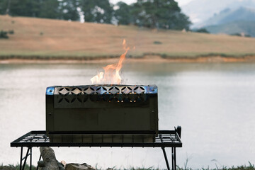 Cast iron fire pit campfire place at forest, camping with bright burning flame. Royalty high-quality free best stock image of A grill with a big fire burning, fire is orange and yellow