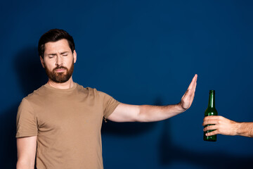 Wall Mural - Photo portrait of mature age brunet bearded funny man in beige t shirt stop sign against alcohol isolated on dark blue color background