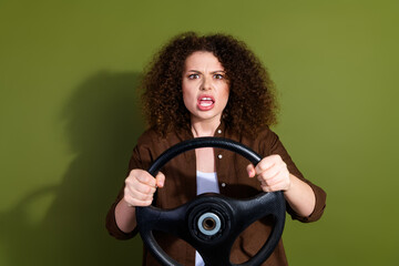 Wall Mural - Photo of pretty young woman hold wheel yell wear brown shirt isolated on khaki color background