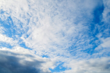 Blue sky background - white dramatic fluffy colorful clouds and sunlight, cloudy blue sky background