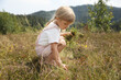 © New Africa - Cute little girl picking flowers at meadow. Child enjoying beautiful nature