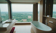 © Miklos - A modern bathroom with a large window overlooking a city skyline