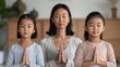 © Shutter2U - A mother and her two daughters meditating together.