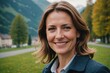 © ThomasLENNE - Close portrait of a smiling 40s Swiss woman looking at the camera, Swiss outdoors blurred background