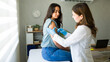 © AntonioDiaz - Medical professional wearing gloves administers a vaccine to a young woman in a doctor's office