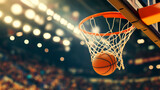 Close-up of a basketball scoring through hoop during a game in a brightly lit indoor arena with blurred audience in the background