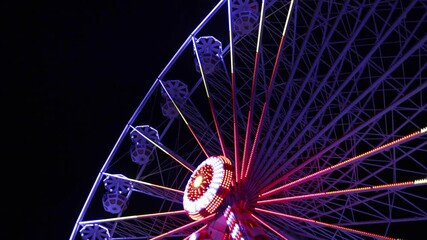 an exquisite ferris wheel illuminated by colorful lights during the vibrant night sky