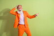 © deagreez - Photo of extravagant glad retired man wear trendy suit demonstrate empty space isolated on green color background