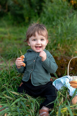 A boy on the shore in the green grass has a picnic