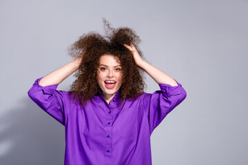 Wall Mural - Photo of nice young woman touch hair empty space wear purple shirt isolated on grey color background