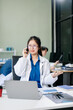 © Nuttapong punna - Confident young female doctor in white medical uniform sit at desk working on computer.