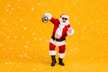 Wall Mural - Full body photo crazy santa claus with grey beard hold disco ball show horns symbol dance x-mas christmas party wear sunglass headwear cap isolated bright shine color background