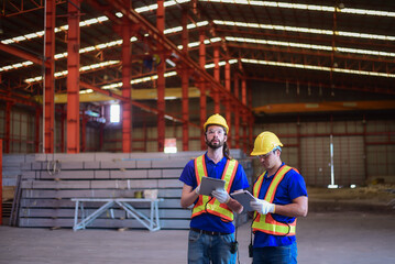 Civil Engineer or Construction engineer and foreman having Check project progress and discussion together for a building plan and architecture development at the construction site of factory