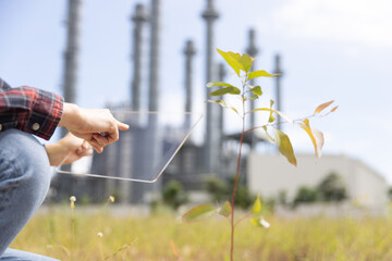 planting trees with clear screen  of renewable resources to reduce pollution ESG icon concept in hand for environmental, beside a thermal power plant 