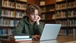© mangz - Young student focused on laptop in cozy library atmosphere