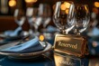 © mitarart - Reserved Sign In Metallic Gold, Reflecting Light, Placed On A Sleek, Modern Restaurant Table With Wine Glasses