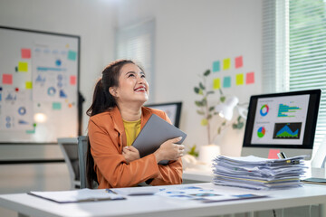 Wall Mural - She is smiling and holding a tablet in her hand