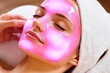 © Konstiantyn Zapylaie - Rejuvenating facial treatment with a glowing pink mask in a spa setting