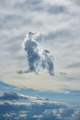 Interesting symbolic shapes of two clouds, large and small, against a white sky. Message from the clouds. High quality photo