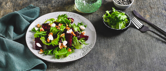 Wall Mural - Delicious salad of beetroot, lettuce, nuts and ricotta on a plate on the table web banner