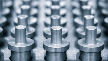 Poster - row metal pins are lined up in a row. pins are all the same size and shape, and they are all facing the same direction. image gives off a sense of order and uniformity, industry concept background.