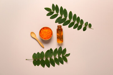 Wall Mural - Bottle of cosmetic oil with leaves and sea salt on grey background