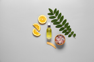 Wall Mural - Bottle of cosmetic oil with lemon and sea salt on grey background