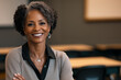 © Rosemarie Mosteller - black teacher smiling in an out of focus classroom with desks behind her