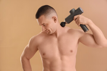 Sticker - Muscular young man massaging his neck with percussive massager on beige background