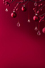 Wall Mural - Burgundy christmas background with wine colored christmas decorations and crystals hanging on fir branches with red berries on rich burgundy background with copy space