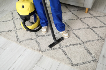 Wall Mural - Female janitor vacuum cleaning carpet in room