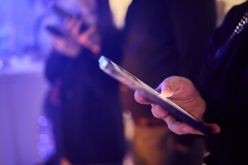 Woman in stylish dress with chic manicure using smartphone in closeup shot