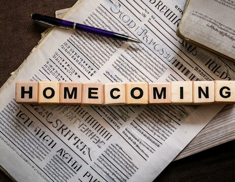 The word 'Homecoming' is written in letters on top of a newspaper