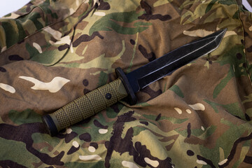 An army knife with a black blade on a MultiCam background