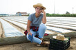 © JackF - Tired farm worker sits on log after covering plants with a covering material