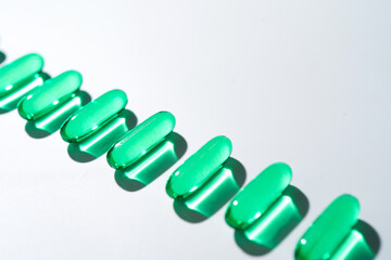 Vitamin E softgel capsules, vitamin D3, fish oil, omega 3, Green oil pills on a white background