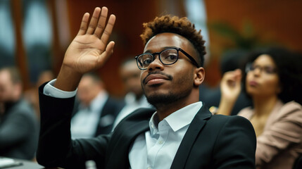 portrait of a businessman sitting in a seminar raising hand to ask a question