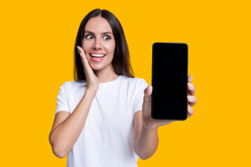 Presenting product. Advertisement of business app. Woman presenting phone screen. Young girl showing phone screen isolated on yellow. Millennial woman. New phone app. Girl offer advertisement