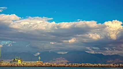 Wall Mural - Time-lapse view of cumulus clouds moving over mountains during daytime.