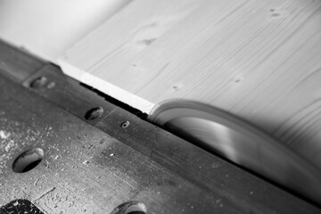 Black and white picture of Carpenter working wood plank circular