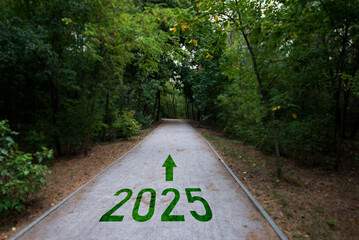 New 2025 concept. The text of the beginning of 2025, written on a road in the middle of the forest. Planning concept, goal, beginning.