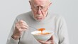 © HadK - Senior Man Suffering from Dysphagia Struggling to Eat Soup - Concept of Swallowing Difficulty in Elderly