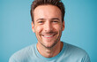 © benjamin - young man smiling looking at camera with a light blue background