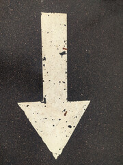 Poster - A simple white arrow painted on the asphalt of a street, pointing towards a direction.